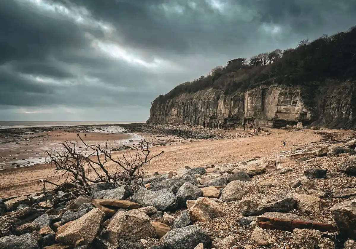 Visitors walking along Pett Level Beach near The Smugglers Retreat